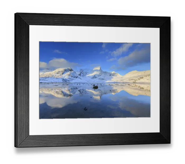 Framed Print : Snow-covered steep mountains reflected in fjord