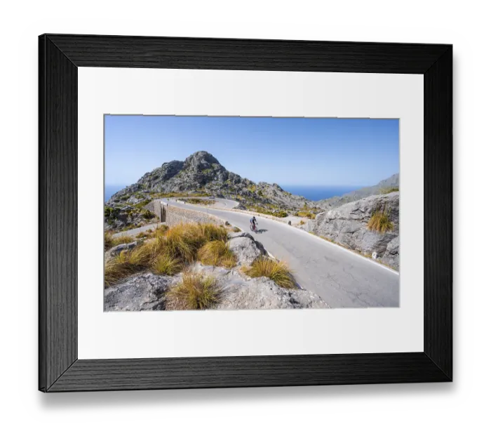 Framed Print : Road cyclists at the mountain pass with serpentines to Sa Colobra