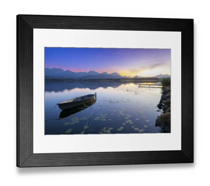 Framed Print : Boats at a jetty on a calm lake at sunset with mountains in the background