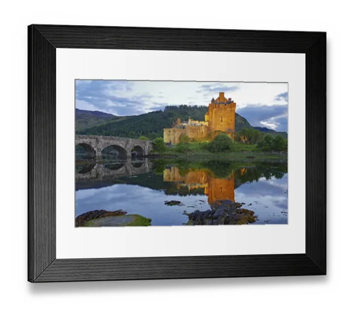 Framed Print : The illuminated Eilean Donan Castle is reflected in the water on a calm evening