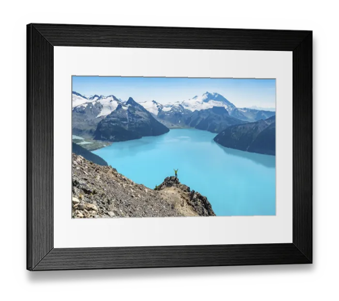 Framed Print : Young man standing on a rock, stretching his arms in the air Framed Print : Young man standing on a rock, stretching his arms in the air