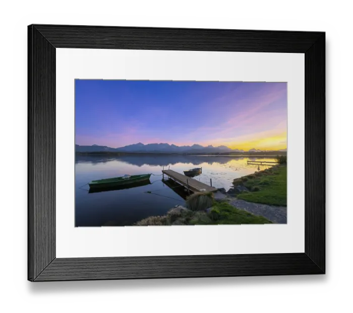 Framed Print : Boats at a jetty on a calm lake at sunset with mountains in the background Framed Print : Boats at a jetty on a calm lake at sunset with mountains in the background