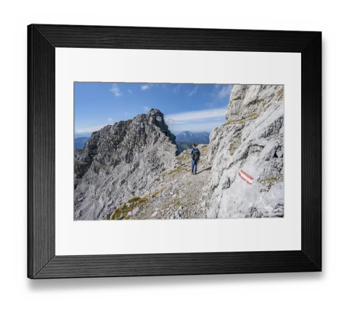 Framed Print : Hiker in rocky terrain, behind rocky ridge with peak Rothoerndl