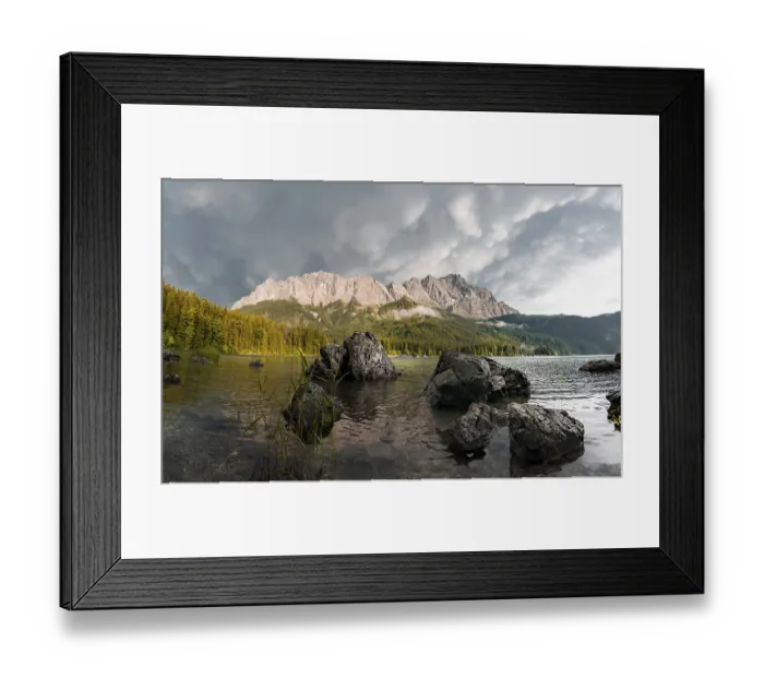 Framed Print : Rocks on the shore, Eibsee lake in front of Zugspitze massif with Zugspitze
