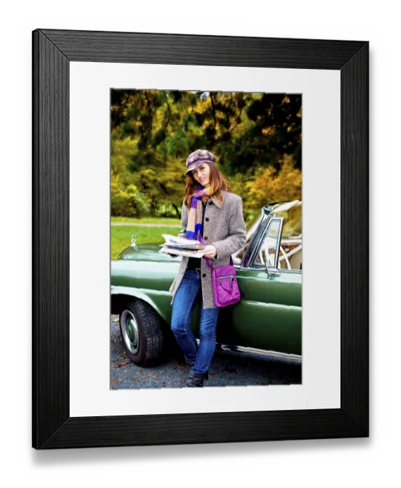 Framed Print : Young woman with a newspaper leaning against a vintage car Framed Print : Young woman with a newspaper leaning against a vintage car