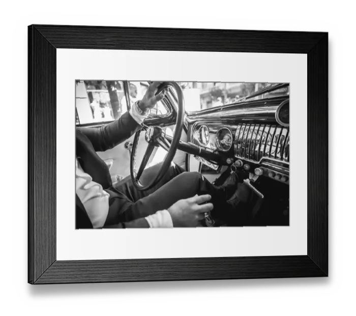 Framed Print : A man in a suit is driving a vintage car