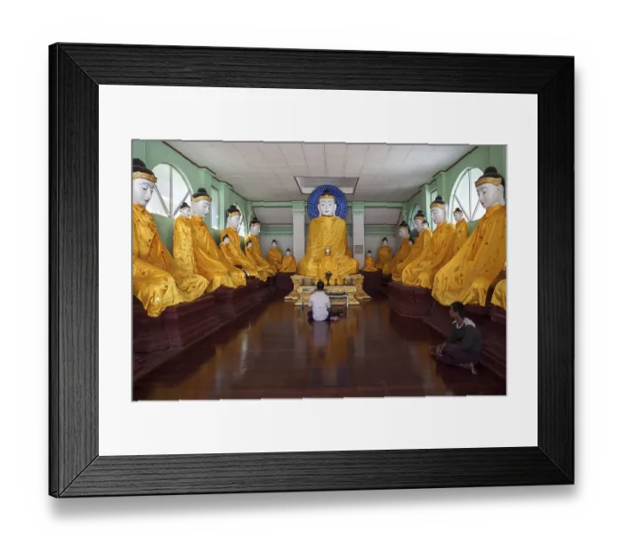 Framed Print : Local man meditating in front of Buddha statues with yellow gowns Framed Print : Local man meditating in front of Buddha statues with yellow gowns