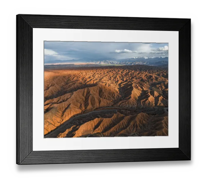 Framed Print : River bed runs through a landscape of eroded hills