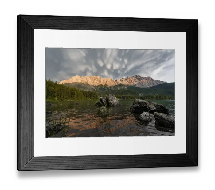 Framed Print : Rocks on the shore, Eibsee lake in front of Zugspitze massif with Zugspitze