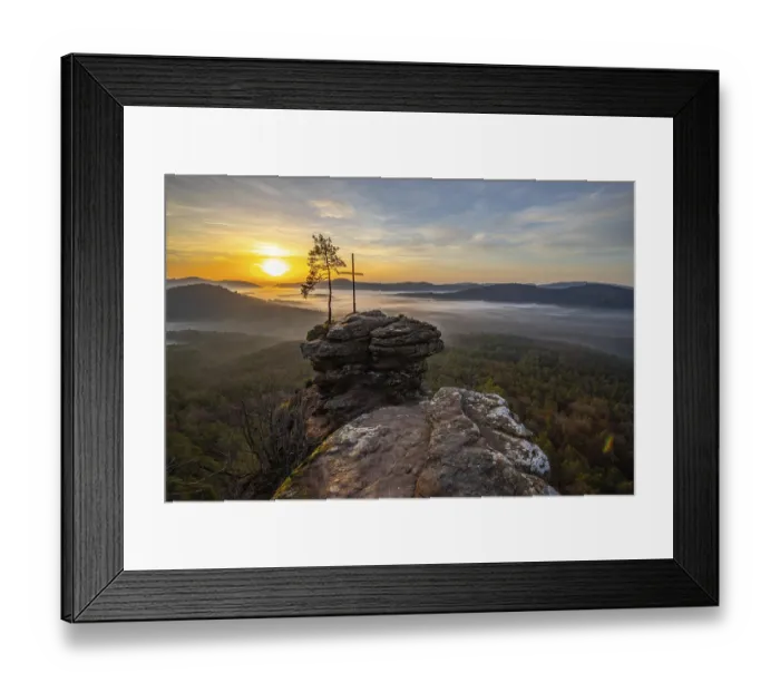 Framed Print : Sunrise on a rock with a summit cross and a view over a forest