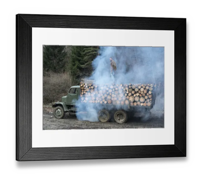 Framed Print : Young man on vintage truck with logs in the forest Framed Print : Young man on vintage truck with logs in the forest