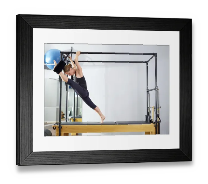 Framed Print : Pilates woman in cadillac split legs stretch exercise at gym Framed Print : Pilates woman in cadillac split legs stretch exercise at gym