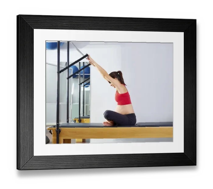 Framed Print : Pregnant woman pilates reformer forward push through exercise workout at gym