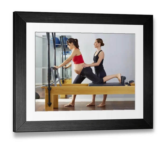 Framed Print : Pregnant woman pilates reformer cadillac exercise workout with personal trainer