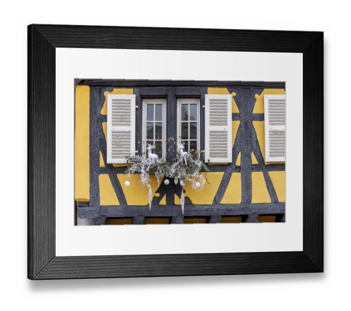 Framed Print : Yellow half-timbered house with a window decorated for Christmas