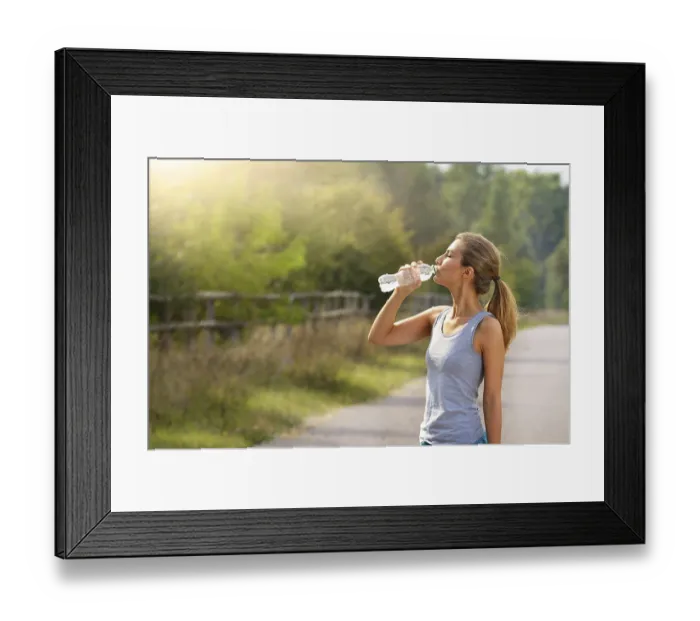 Framed Print : Young woman drink water while jogging outdoors