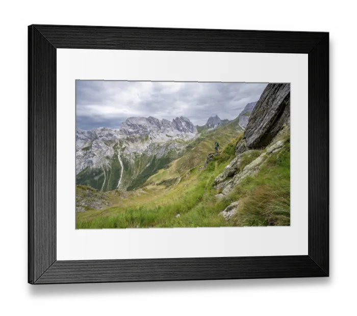 Framed Print : Mountaineer on a narrow hiking trail on a steep meadow slope