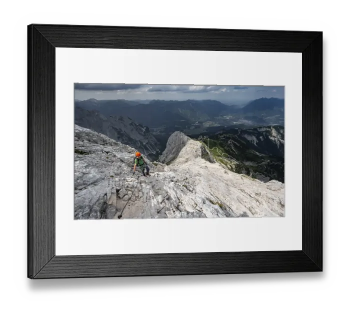 Framed Print : Mountaineer with helmet climbing on the rock in a secured climb