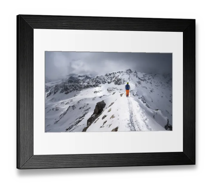 Framed Print : Mountaineer descending the narrow ridge of Piz Laviner