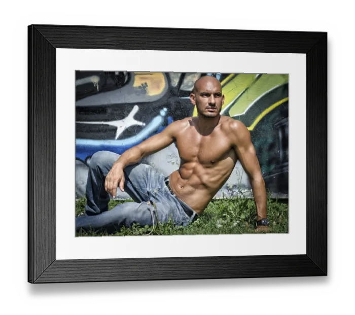Framed Print : Bald young man shirtless outdoors sitting in front of graffiti wall on grass Framed Print : Bald young man shirtless outdoors sitting in front of graffiti wall on grass
