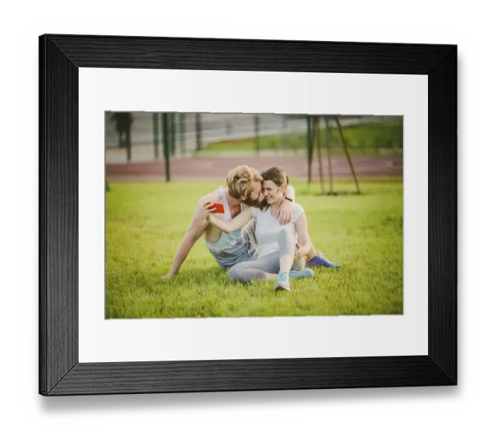 Framed Print : Sport and technology. Young in love heterosexual Caucasian couple resting after workout outdoors in park on lawn