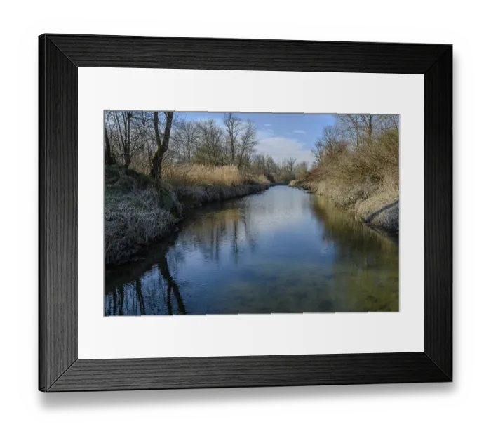 Framed Print : Clear water of a river with reflection of trees and sky in quiet surroundings Framed Print : Clear water of a river with reflection of trees and sky in quiet surroundings