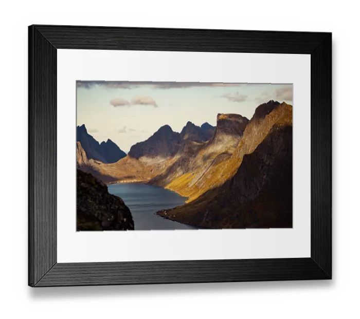 Framed Print : Dramatic view of a fjord with towering mountains casting shadows along the landscape