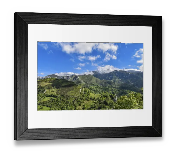 Framed Print : Scenic view of green hills and mountains under a bright blue sky with scattered clouds
