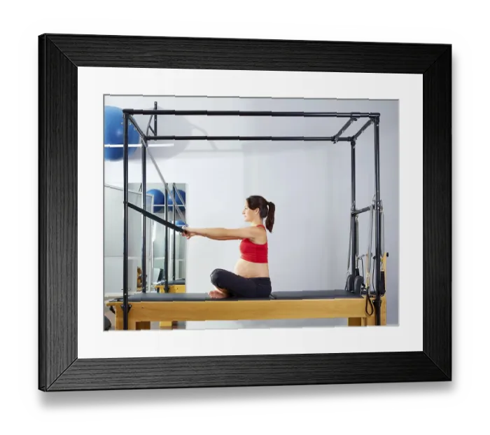 Framed Print : Pregnant woman pilates reformer forward push through exercise workout at gym