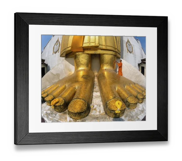 Framed Print : Monk praying at the feet of the golden Buddha statue of Wat Intharawihan