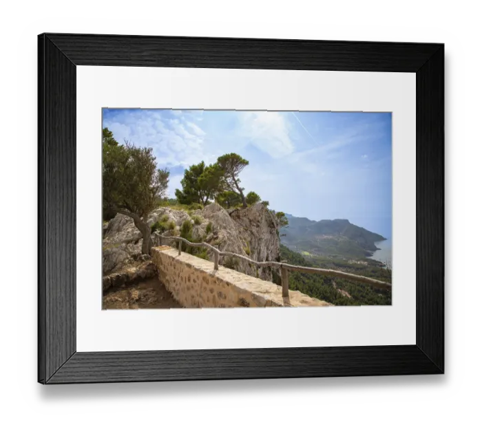 Framed Print : A picturesque cliff landscape with trees and a view of the sea and the coast under a blue sky