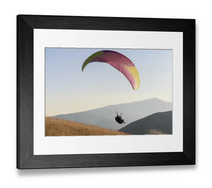 Framed Print : Paragliding flight in the air over the mountains