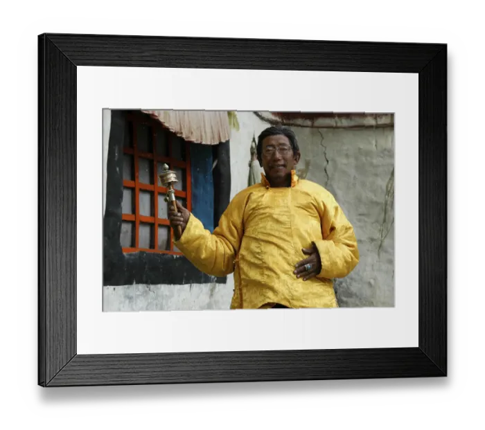 Framed Print : Monk Lama Sonom dressed in a yellow cape turning a prayer wheel in front of monastery Tashi Gompa Phu Nar-Phu Annapurna