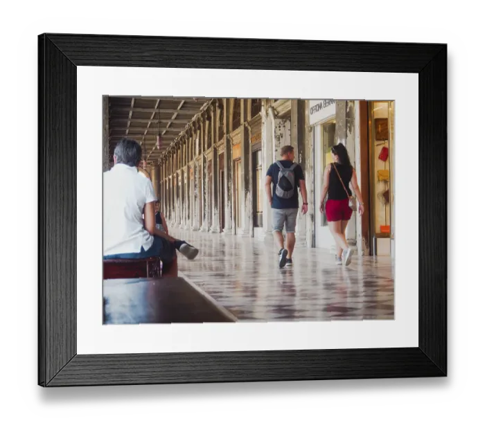 Framed Print : Tourists walk and sit under a covered arcade with historical architecture and mosaic floors