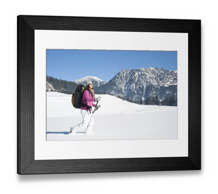 Framed Print : Woman hiking in the snow in the mountains