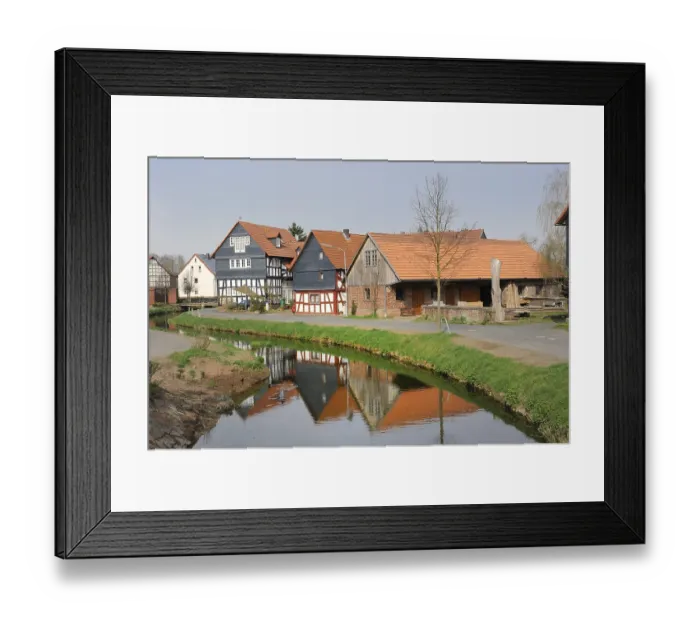 Framed Print : Half-timbered houses being reflected in the water of the Treisbach creek Framed Print : Half-timbered houses being reflected in the water of the Treisbach creek