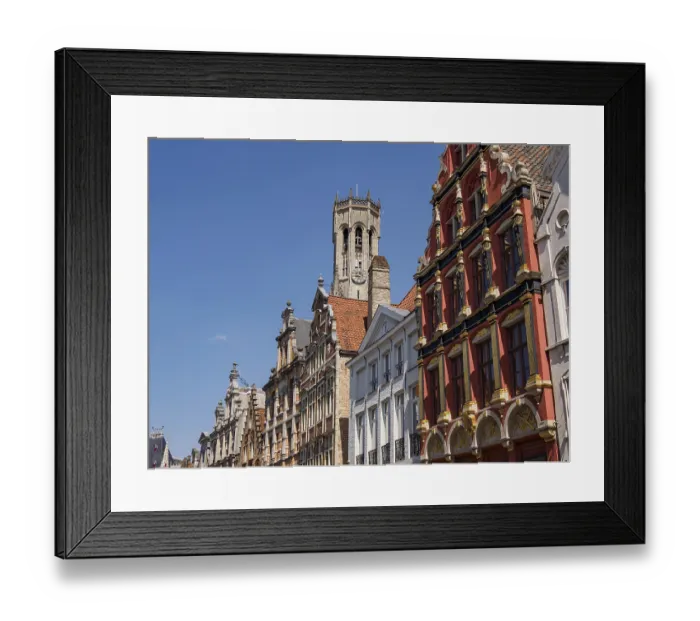 Framed Print : City scene with historic buildings with red facades and a bell tower under a clear blue sky