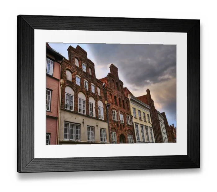 Framed Print : Historic brick architecture with rows of windows under a dramatically cloudy sky in an old town