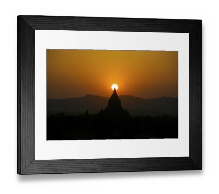 Framed Print : Orange sunset, silhouette with the sun behind the steeple of a Buddhist temple