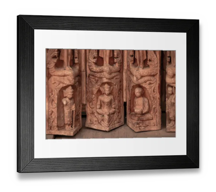 Framed Print : A detailed wooden carving depicting multiple Buddhist figures in meditation and standing poses