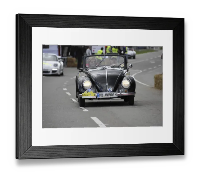 Framed Print : An old Volkswagen Beetle convertible drives past spectators at a car race Framed Print : An old Volkswagen Beetle convertible drives past spectators at a car race