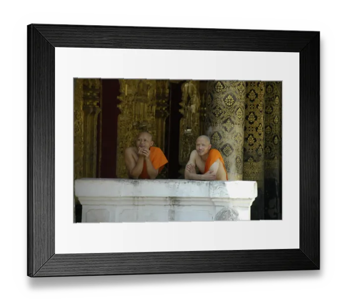 Framed Print : Buddhist monks leaning against a wall of Wat Mai Suwannaphumaham