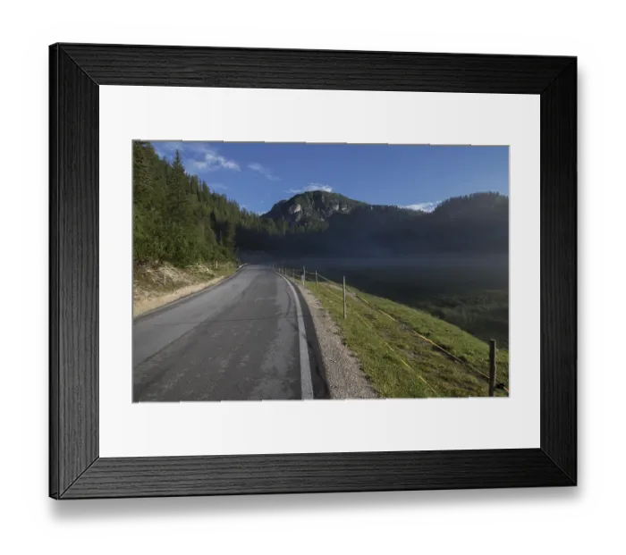 Framed Print : A small, light morning fog rising above the meadow by the asphalt road