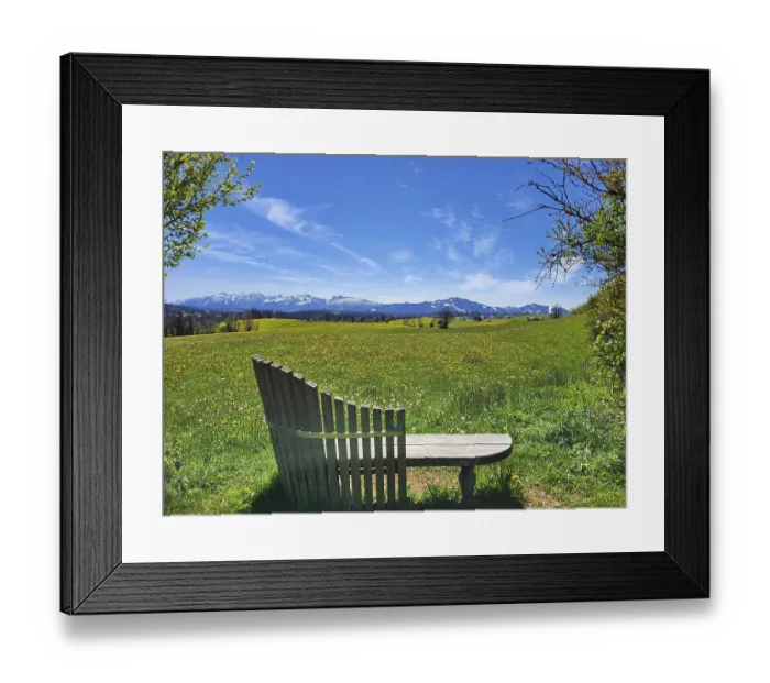 Framed Print : A peaceful landscape with a wooden bench in the foreground