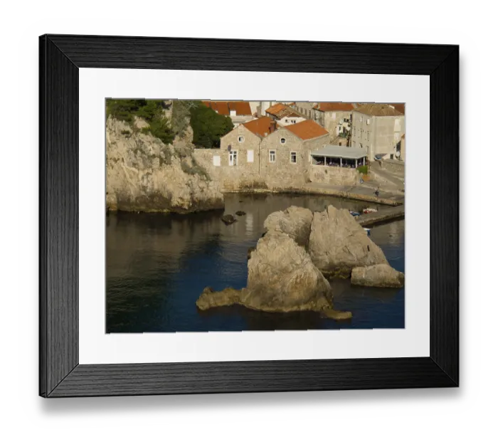 Framed Print : Coastal town with rocky shores and calm waters