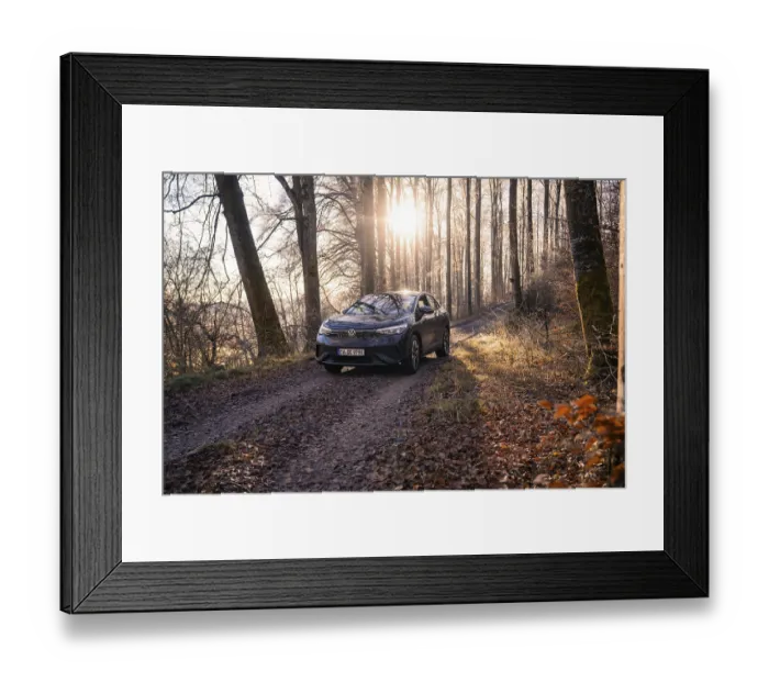 Framed Print : Vehicle on a forest path, illuminated by sunlight through the trees