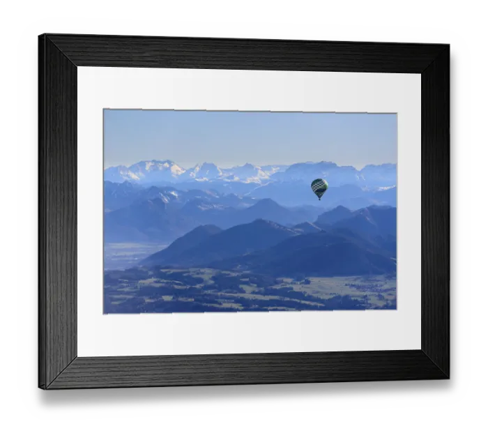 Framed Print : Hot air balloon flying in front of a mountain landscape