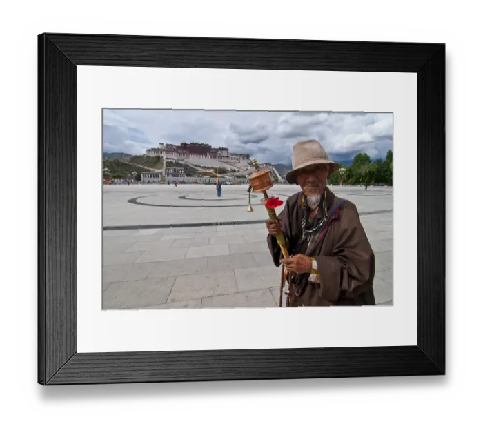 Framed Print : Pigrim with a prayer wheel in front of the Potala Palace