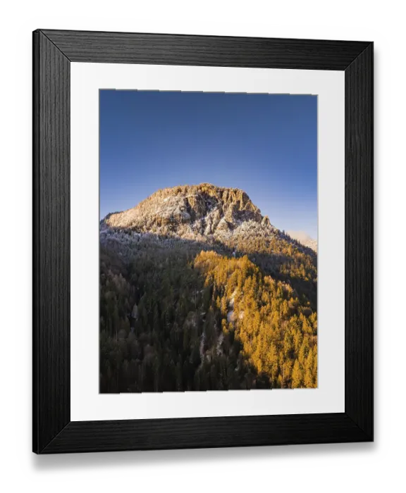 Framed Print : Snow-covered mountain peak above an autumnal forest
