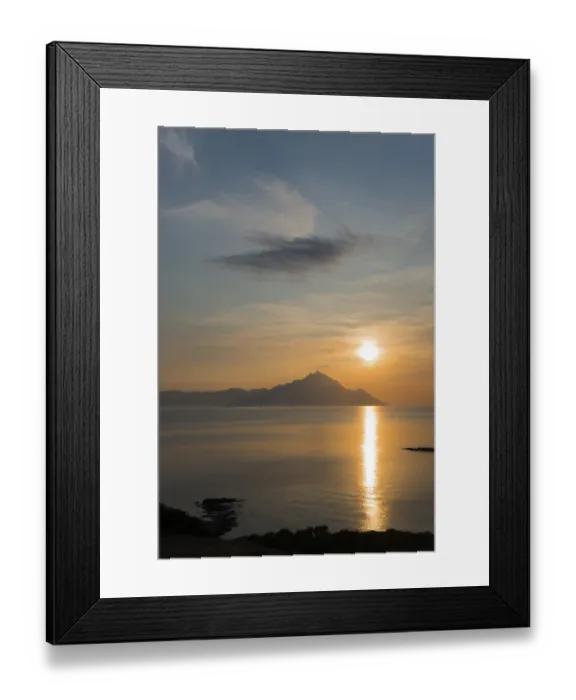 Framed Print : Sunrise over a mountain with clouds and reflections on the water surface